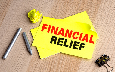 FINANCIAL RELIEF text on yellow sticky on wooden background
