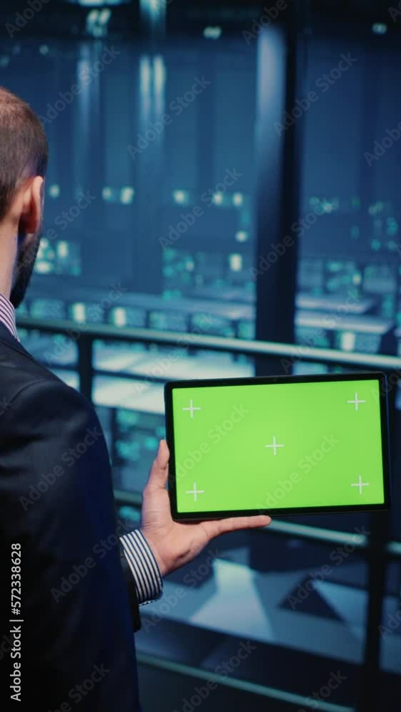 Poster vertical video: support specialist using tablet with greenscreen display in modern data center, chec