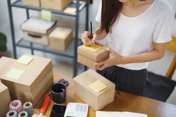 Fototapeta na wymiar Asian woman preparing package delivery box Shipping for shopping online. young start up small business owner 