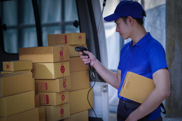 Deliver service. Man With Box in Car Outdoors Delivery Man in uniform holds parcel and phone car outdoors Delivery man taking parcels from The Delivery service