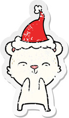 happy distressed sticker cartoon of a polar bear wearing santa hat