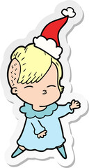 sticker cartoon of a squinting girl wearing santa hat