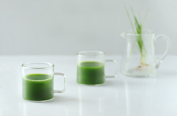 Wheat grass juice on the light  gray background