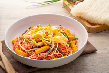 Stir fry rice vermicelli with Yen Ta Fo sauce.Pink sweet and sour thin rice noodles in white plate.Most popular and well known noodle dishes in Thailand