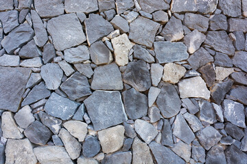 Stones of different shapes and sizes are built into the wall