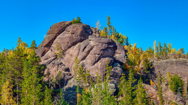 High rocks surrounded by coniferous forests for advanced hiking and alpinism. High resolution photo.