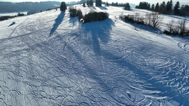 Drohnenvideo von einem Kitesurfer im Winter im Schnee. Snowkite im Gebirge