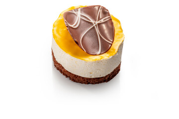 Yellow glazed cheese cake with chocolate decoration. Exquisite Fresh delicious dessert on white isolated background with shadow.