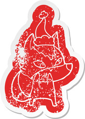 shy cartoon distressed sticker of a wolf wearing santa hat