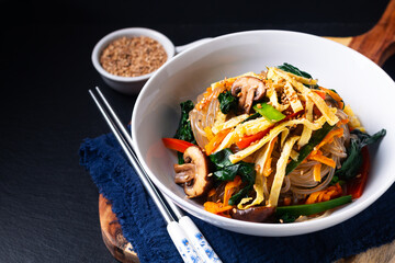 Food concept homemade Japchae korean potato noodles on black background