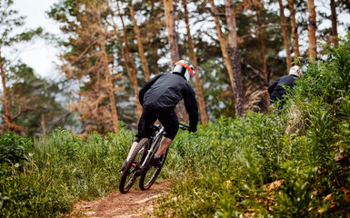 downhill mountain rider athlete rides on trail in forest