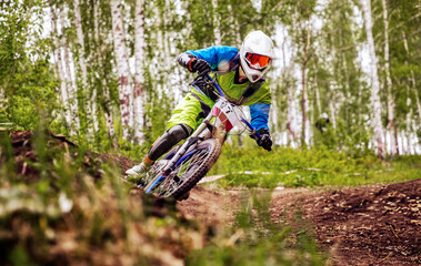 athlete mountain biker riding turn in forest trail