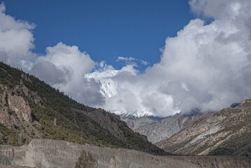 View of the high altitude plateau with Annapurna range in clouds (in the background) on the approach to Manang village, Manang district, Around Annapurna trek, Nepal Himalayas, Nepal