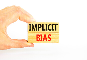 Implicit bias symbol. Concept words Implicit bias on wooden block. Beautiful white table white background. Businessman hand. Business psychology implicit bias concept. Copy space.