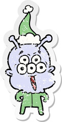 happy distressed sticker cartoon of a alien wearing santa hat