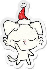 cute distressed sticker cartoon of a dog wearing santa hat