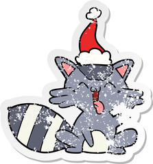 cute distressed sticker cartoon of a raccoon wearing santa hat