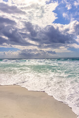 Vertical image of sea at midday with cloud filled sky.