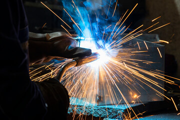 Industrial steel welder in a factory. Welder at work.