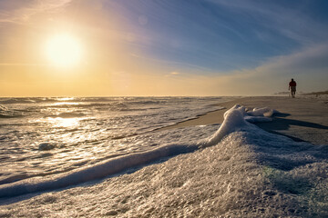 Fototapeta na wymiar Sea foam and sun on the horizon before nightfall