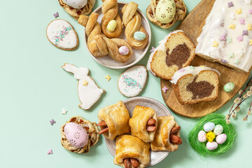 Festive dinner, Easter brunch. Happy Easter holiday food baking puff pastry and cupcake with Easter Bunny on pastel green background. View from above. Copy space.