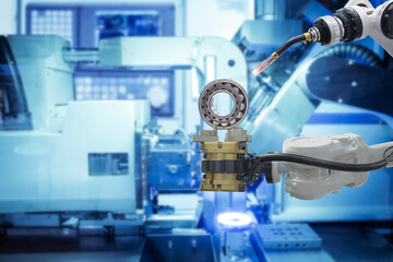 Close-up industrial welding robotics working with metalwork from gripping robot on smart factory with blue tone background, industry 4.0 and automation working via no people control
