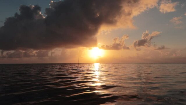amanecer en el muelle con nubarrones y sol saliendo frente al mar del caribe