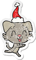 laughing distressed sticker cartoon of a dog wearing santa hat