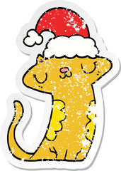 distressed sticker of a cute cartoon cat wearing christmas hat