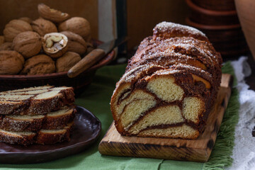 Traditional Easter bread with chocolate and nut filling on a wooden background.