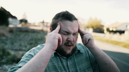Person suffering from mental pain. Closeup face of one male fat caucasian man pressing temples...