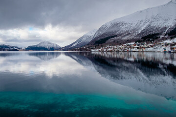 calm ocean with reflection of mountains