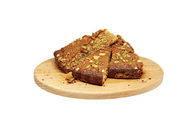  several pieces of homemade sponge cake with nuts on a wooden cutting board
