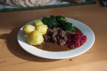 ready to eat, delicious goulash of chamois meat in a brown sauce with potatoes and cranberries