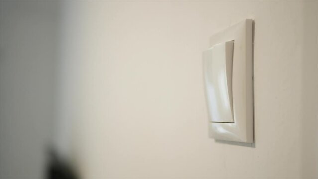 Opening the Light from the Switch in the Office. One Person Turning on the Light in a Room. Saving Electricity, Economy Concept.