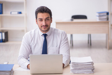 Young male employee and too much work in the office