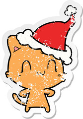 distressed sticker cartoon of a happy cat wearing santa hat