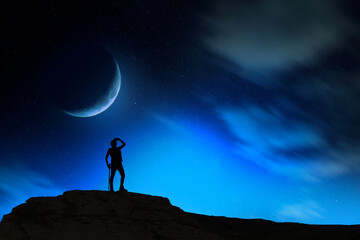 Silhouette of a person standing on the full moon background.