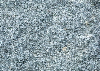 Texture of gray stone in a low wall. Nature, rock, natural material, cut stone, mineral, granite, sandstone. Macro, close-up, background