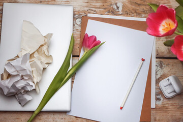 Workplace - laptop, headphones, paper and pen - a creative mess with flowers