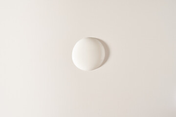 A round drop of cosmetic cream. A white creamy drop of skin care cream. A smooth drop isolated on a white background with space to copy. High quality photo