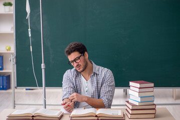 Young male teacher suffering in the classroom