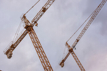Grúas de construcción vistas desde abajo con el cielo de fondo 