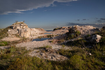 Quartz open cast mine at sunset. View of the white quartz hills with beautiful dusk light.	