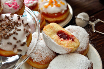 Preparing many types of donuts for traditional party Fat Thursday or Shrove Tuesday - table top view with sweet pastries on plates.
