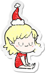 happy distressed sticker cartoon of a elf girl wearing santa hat