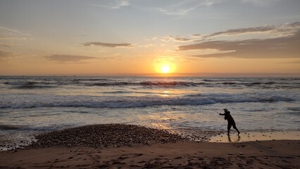 Fototapeta na wymiar fisherman on the beach at sunset