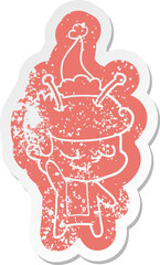 friendly cartoon distressed sticker of a spaceman wearing santa hat