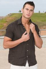 attractive young man with his shirt unbuttoned outdoors