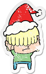 distressed sticker cartoon of a boy with untidy hair wearing santa hat
